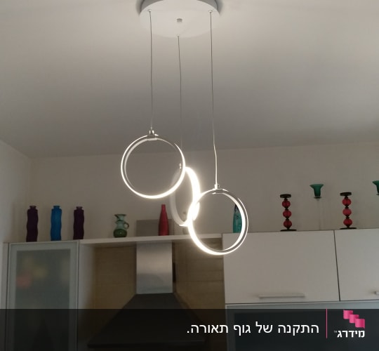 נברשת עגולה תלויה מהתקרה עם תאורה לבנה